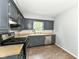 Kitchen with grey cabinetry, stainless steel appliances, and wood-look flooring at 114 South St, Southport, IN 46227