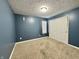 Bedroom featuring neutral carpet, blue paint, modern light and a double closet at 1202 Tomahawk Pl, Martinsville, IN 46151