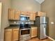 Well-equipped kitchen boasts stainless steel appliances, wood cabinets, and laminate countertops at 1202 Tomahawk Pl, Martinsville, IN 46151