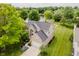Aerial view of home highlighting manicured lawn, mature trees and neighborhood lake for scenic outdoor living at 12490 Windbush Way, Carmel, IN 46033