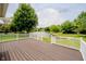 Inviting back deck with white railing overlooking a serene lake view surrounded by mature trees at 12490 Windbush Way, Carmel, IN 46033