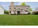 Well-maintained backyard with a charming deck area, lush green lawn, and a beautiful home exterior at 12490 Windbush Way, Carmel, IN 46033