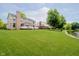 Expansive backyard featuring lush green grass, a lake view and a spacious deck perfect for outdoor enjoyment at 12490 Windbush Way, Carmel, IN 46033