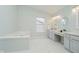 Bright bathroom features a soaking tub, double sinks, vanity space, and natural light at 12490 Windbush Way, Carmel, IN 46033