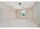 Bright bedroom with a window, neutral walls and carpet, and a modern light fixture at 12490 Windbush Way, Carmel, IN 46033