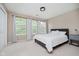 Bedroom with three windows, carpet, white bedspread and grey headboard, and a modern light fixture at 12490 Windbush Way, Carmel, IN 46033