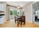 Bright dining area with a modern light fixture, wood table, and sliding glass doors overlooking the backyard at 12490 Windbush Way, Carmel, IN 46033