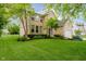 Charming two-story brick home with a lush green lawn and mature trees at 12490 Windbush Way, Carmel, IN 46033