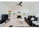 Spacious living room showcasing a fireplace, black leather sofa, modern coffee table, and a ceiling fan at 12490 Windbush Way, Carmel, IN 46033