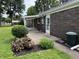 Brick home with a covered patio area, landscaping and a well-maintained yard at 1400 Evelyn Ln, Anderson, IN 46017