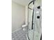 Bathroom featuring a new shower with glass doors, toilet, and unique patterned tile floors at 1400 Evelyn Ln, Anderson, IN 46017