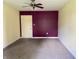 A bedroom with neutral and maroon walls and carpeted flooring at 1400 Evelyn Ln, Anderson, IN 46017