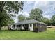 Brick home on a large lot with manicured lawn, flowerbeds and covered front porch at 1400 Evelyn Ln, Anderson, IN 46017