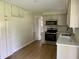 Modern kitchen with white cabinets, stainless steel appliances, and hardwood floors at 1400 Evelyn Ln, Anderson, IN 46017