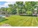 Expansive backyard featuring lush grass, a patio with seating, and mature trees for privacy at 15075 Windsor Ln, Noblesville, IN 46060