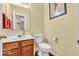 Clean bathroom with wood-look flooring, wood vanity, toilet, sink, and large mirror at 15075 Windsor Ln, Noblesville, IN 46060