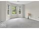 Bright bedroom with three large windows offering natural light and a view, set in a spacious and neutral-toned room at 15075 Windsor Ln, Noblesville, IN 46060