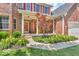 Charming brick home with a well-manicured front yard, flowers, and inviting porch at 15075 Windsor Ln, Noblesville, IN 46060