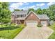 Charming two-story brick home featuring a well-manicured lawn, two-car garage, and inviting front porch at 15075 Windsor Ln, Noblesville, IN 46060