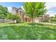 Landscaped front yard showcases a brick home with a charming porch and well-maintained lawn at 15075 Windsor Ln, Noblesville, IN 46060