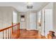 Elegant hallway with hardwood floors and a wooden railing, offering a view into adjacent rooms and natural light at 15075 Windsor Ln, Noblesville, IN 46060