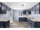 This kitchen features navy cabinets, gray counter tops, a double sink, and wood-look flooring at 1739 N Alton Ave, Indianapolis, IN 46222