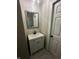 A bathroom has a vanity with a sink, a mirror, and a neutral-colored tiled wall at 1810 N Parker Ave, Indianapolis, IN 46218