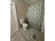 A full bathroom has a toilet and a shower with a patterned shower curtain and tiled floor at 1810 N Parker Ave, Indianapolis, IN 46218