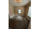 An empty bedroom with carpet has one small window with white blinds and a modern ceiling light at 1810 N Parker Ave, Indianapolis, IN 46218