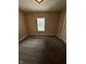 A carpeted empty bedroom has a window with white blinds and neutral-colored walls at 1810 N Parker Ave, Indianapolis, IN 46218