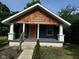Charming home featuring cedar shake, an orange door, and a covered front porch at 1810 N Parker Ave, Indianapolis, IN 46218