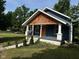 Charming home featuring cedar shake, an orange door, and a covered front porch at 1810 N Parker Ave, Indianapolis, IN 46218