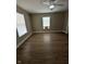 Spacious living room with a ceiling fan, wood floors, and two bright windows at 1810 N Parker Ave, Indianapolis, IN 46218