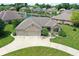 This aerial image showcases the house with a beautiful pond view, green lawn, and big drive way at 182 Southwind Ln, Greenwood, IN 46142