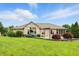 Spacious backyard with green lawn, garden beds, and brick elevation at 182 Southwind Ln, Greenwood, IN 46142
