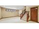 Basement features stairs, baseboard trim, and a window adding natural light to a versatile living space at 182 Southwind Ln, Greenwood, IN 46142