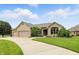 A brick home with meticulous landscaping, three-car garage, and a curved driveway at 182 Southwind Ln, Greenwood, IN 46142