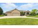 A charming brick home boasts a well-manicured lawn and a spacious three-car garage at 182 Southwind Ln, Greenwood, IN 46142