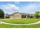 Traditional brick home featuring a manicured front yard with a circular driveway and mature trees at 182 Southwind Ln, Greenwood, IN 46142
