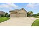 This image shows a three-car garage and driveway with a beautifully landscaped lawn at 182 Southwind Ln, Greenwood, IN 46142