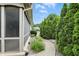 Well-maintained side yard with lush greenery, a stone pathway, and a screened-in porch at 182 Southwind Ln, Greenwood, IN 46142