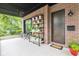 Covered brick porch with black ceiling fan, flower display, and a stylish wooden front door at 1905 N Alabama St, Indianapolis, IN 46202