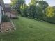 Spacious lawn with a deck, complemented by lush trees and greenery along the water's edge at 21 Watson Dr, Trafalgar, IN 46181
