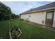 Landscaped backyard featuring a grass lawn, flower beds, and a small wooden deck at 21 Watson Dr, Trafalgar, IN 46181