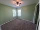 A bright bedroom featuring neutral carpet, a ceiling fan, and two windows at 21 Watson Dr, Trafalgar, IN 46181