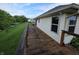 Long wooden deck along the side of a house overlooking a grassy yard and mature trees at 21 Watson Dr, Trafalgar, IN 46181