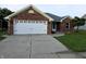 Charming single-story red brick home featuring an attached two-car garage and well-manicured front lawn at 21 Watson Dr, Trafalgar, IN 46181