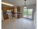 Bright eat-in kitchen with wood cabinets, white appliances, and sliding glass doors leading to an outdoor deck at 21 Watson Dr, Trafalgar, IN 46181
