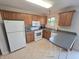 Well-lit kitchen features wood cabinetry, a gray countertop, and white appliances, offering a practical cooking space at 21 Watson Dr, Trafalgar, IN 46181