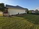 Home exterior featuring light siding, well-kept lawn, minimal landscaping, and a partial brick front at 21 Watson Dr, Trafalgar, IN 46181